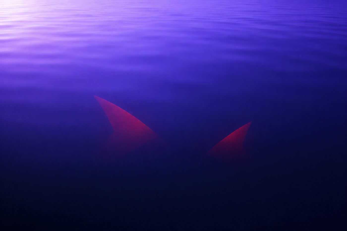 A calm level surface of pale indigo liquid with two sharp red shapes barely visible just beneath it